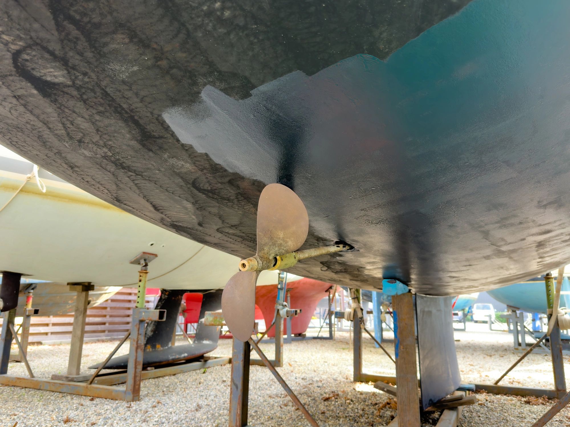 Sailing boat on stilts being painted with antifouling